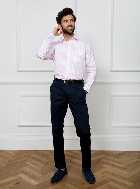 Man wearing long sleeved shirt with pale pink and white stripe made with 100% cotton from Thomas Mason.